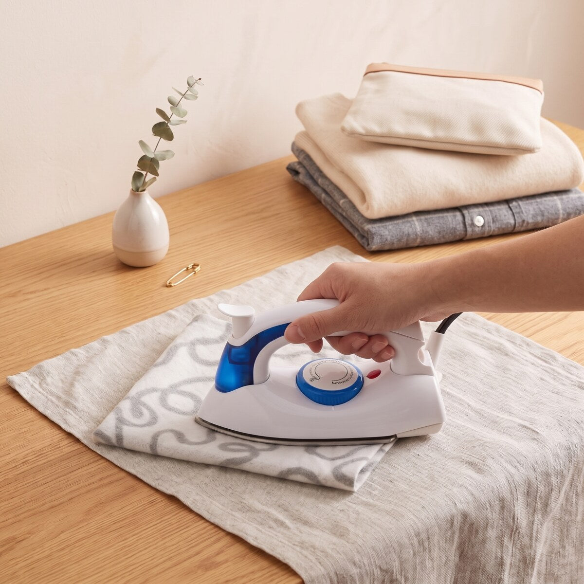 Ironing linen on a table with the mini travel steam iron